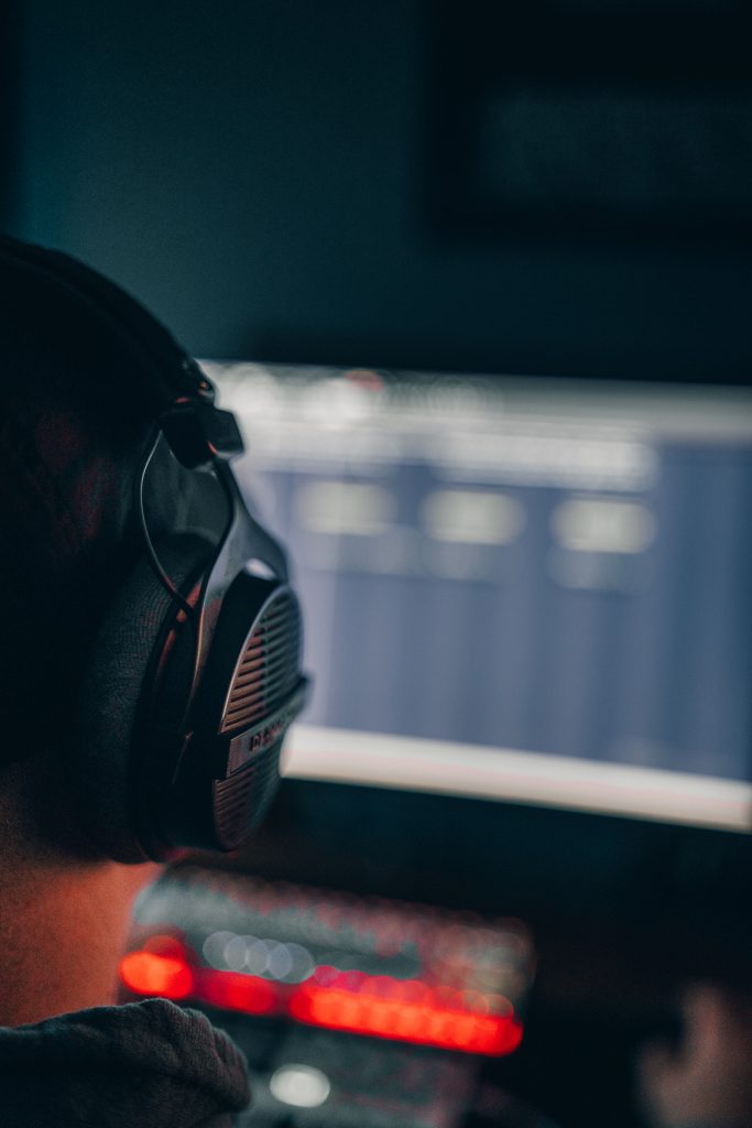 Beat Producer am PC arbeitet mit FL Studio. Producer von hinten fotografiert. moody fotoshooting zu Hause