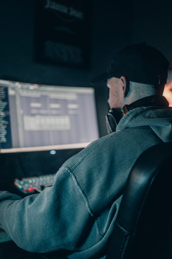 Ein Beat Producer am PC arbeitet mit FL Studio, moody fotoshooting zu Hause